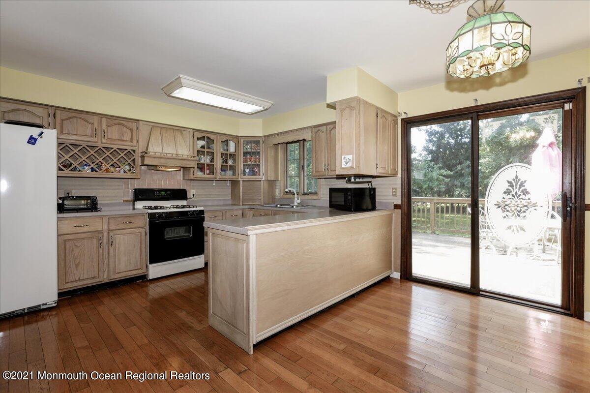 41 Haines Street Lanoka Harbor, NJ 08734 - Photo 15 of 43 a kitchen with stainless steel appliances granite countertop a stove top oven a refrigerator a sink and dishwasher with wooden floor