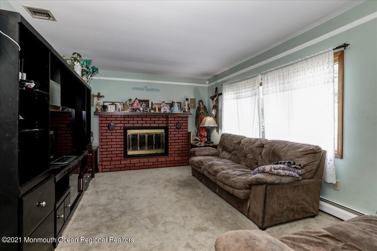 41 Haines Street Lanoka Harbor, NJ 08734 - Photo 8 of 43 a living room with furniture a flat screen tv and a fireplace