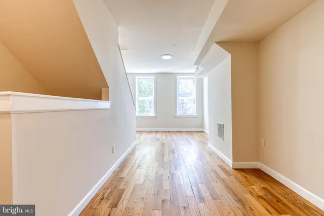 a view of a room with wooden floor and window