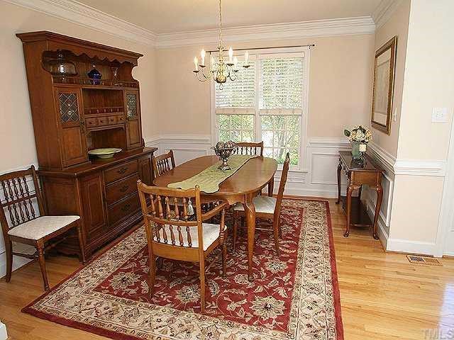 9109 Dawnshire Road Raleigh, NC 27615 - Photo 3 of 12 a dining room with furniture a rug a rug and wooden floor
