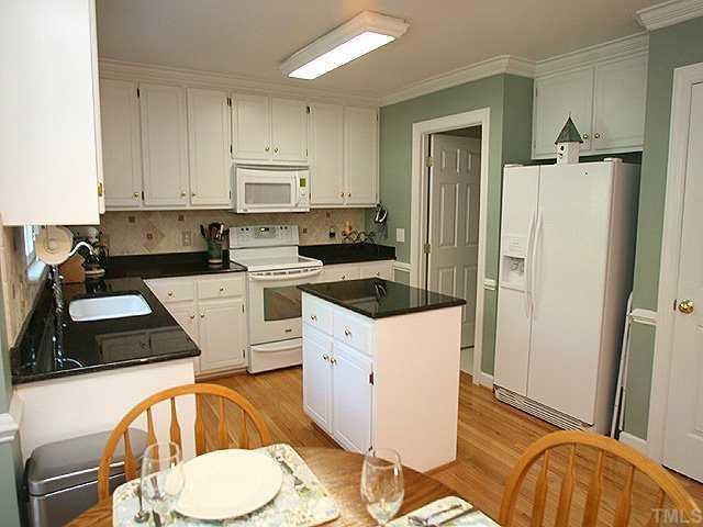 9109 Dawnshire Road Raleigh, NC 27615 - Photo 4 of 12 a kitchen with a sink a stove and refrigerator