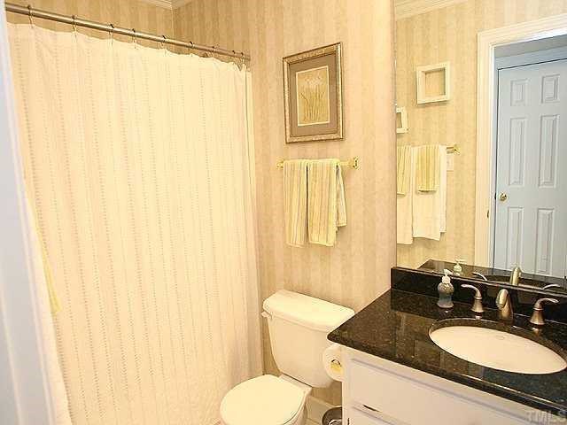 9109 Dawnshire Road Raleigh, NC 27615 - Photo 10 of 12 a bathroom with a granite countertop sink and a mirror