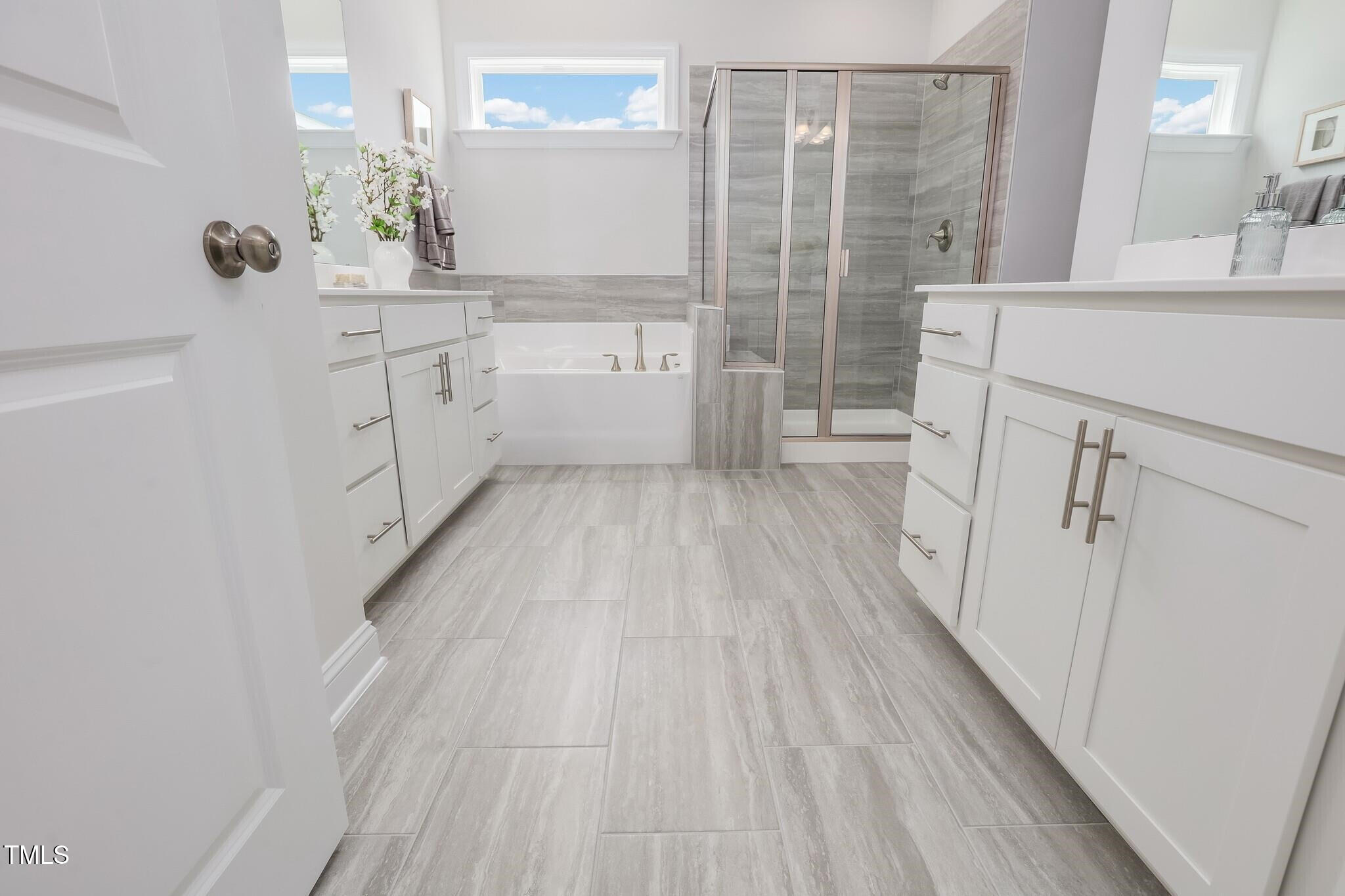 361 Calvander Lane Apex, NC 27539 - Photo 32 of 47 a bathroom with a sink a mirror and a shower