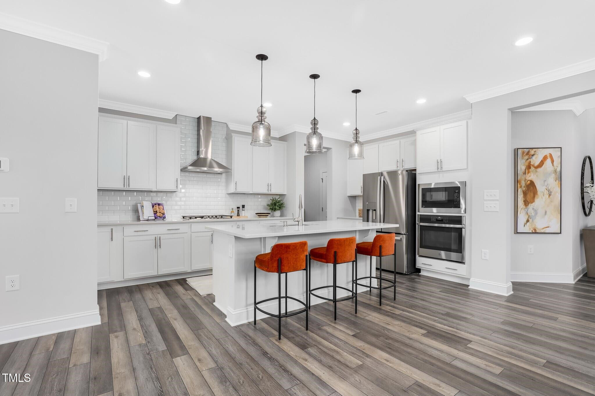 361 Calvander Lane Apex, NC 27539 - Photo 6 of 47 a kitchen with stainless steel appliances granite countertop a refrigerator a oven a stove and white cabinets with wooden floor