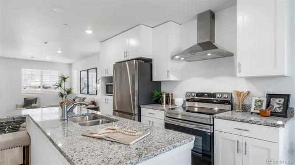 a kitchen with stainless steel appliances granite countertop a sink stove and refrigerator