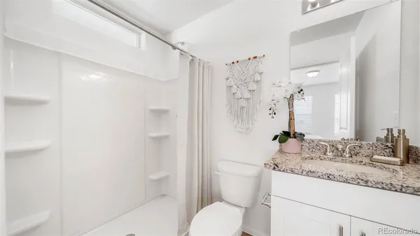 a bathroom with a granite countertop sink toilet and shower