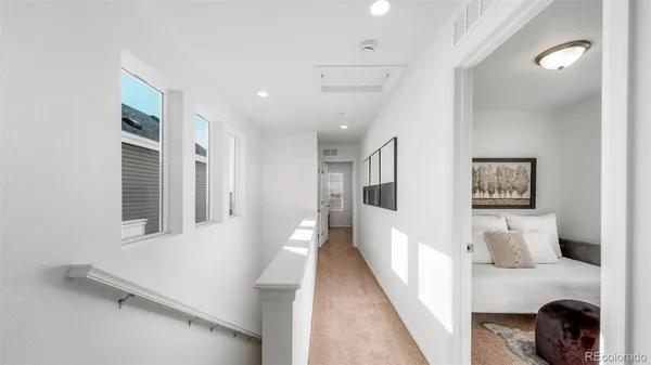 a hallway with a white cabinets and wooden floor