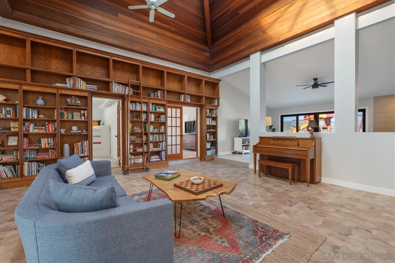 11869 Hi Ridge Road Lakeside, CA 92040 - Photo 19 of 73 a living room with furniture a piano and a bookshelf