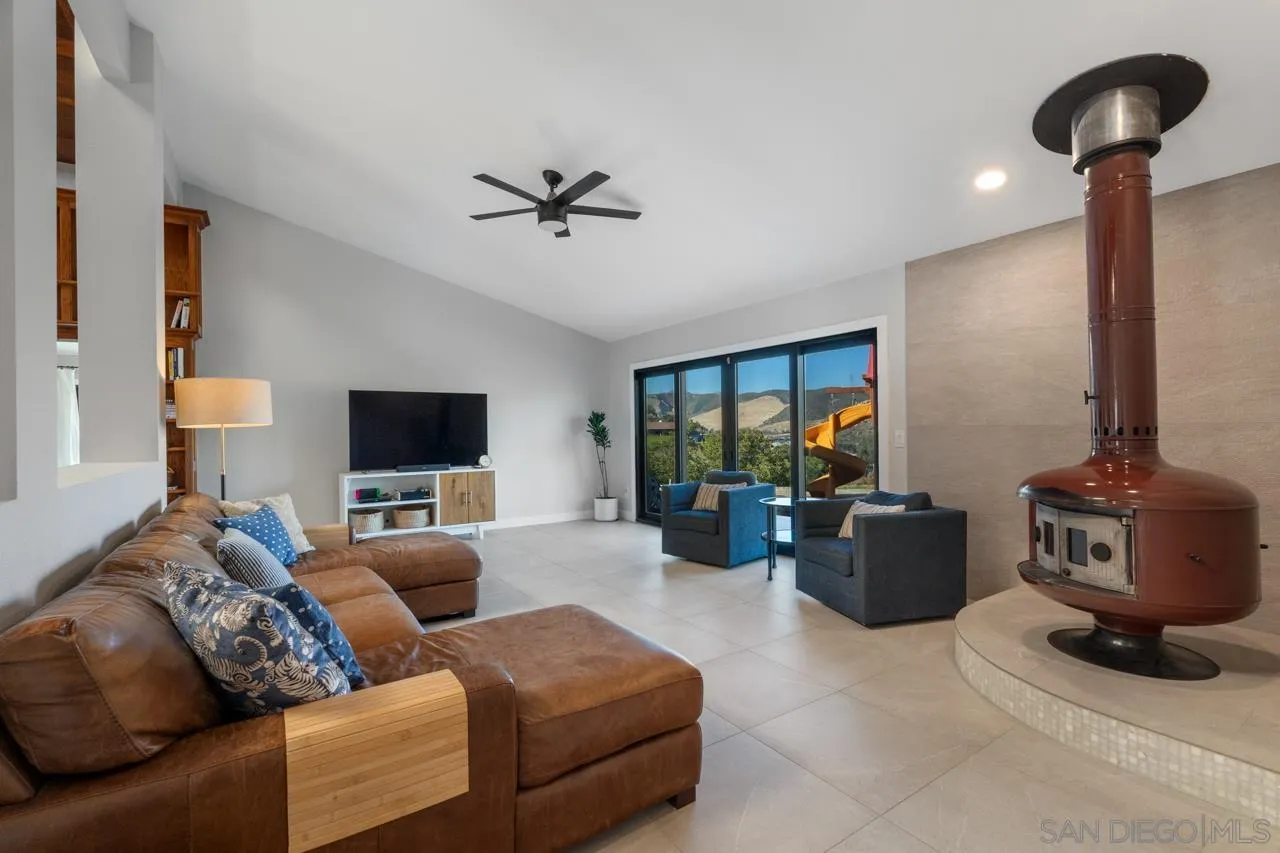 11869 Hi Ridge Road Lakeside, CA 92040 - Photo 21 of 73 a living room with furniture a lamp and a flat screen tv