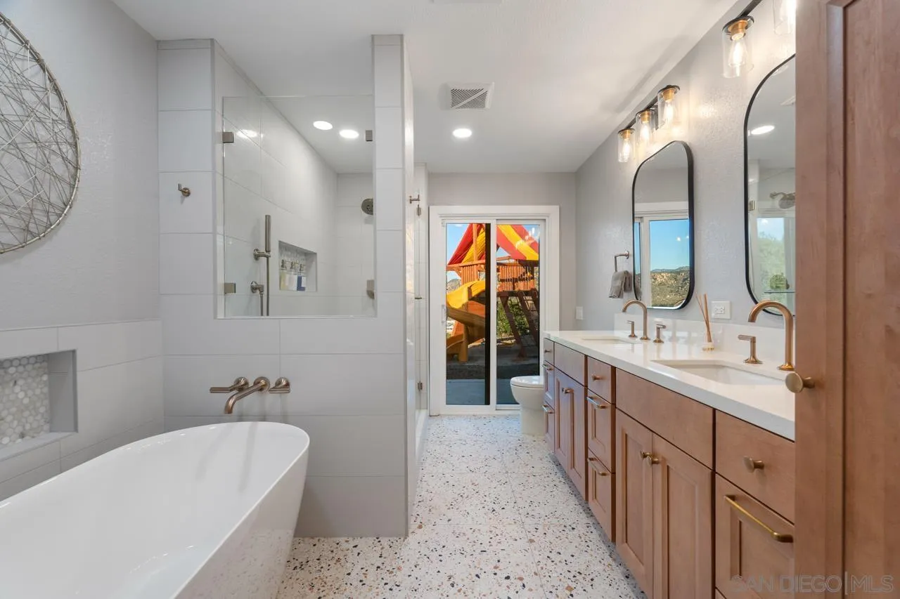 11869 Hi Ridge Road Lakeside, CA 92040 - Photo 41 of 73 a spacious bathroom with a double vanity sink a large mirror and a bathtub