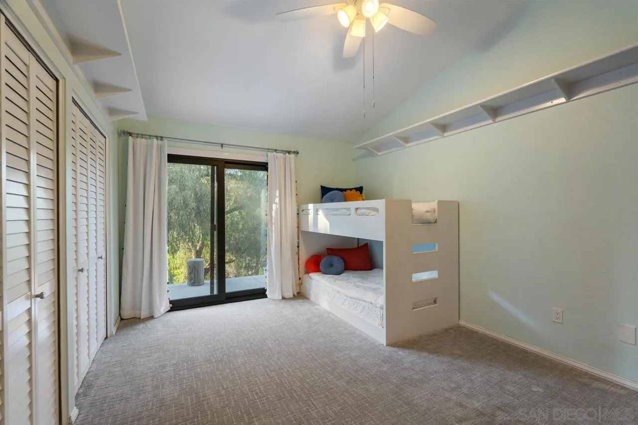 11869 Hi Ridge Road Lakeside, CA 92040 - Photo 54 of 73 a view of a bedroom with baby bed and a chandelier