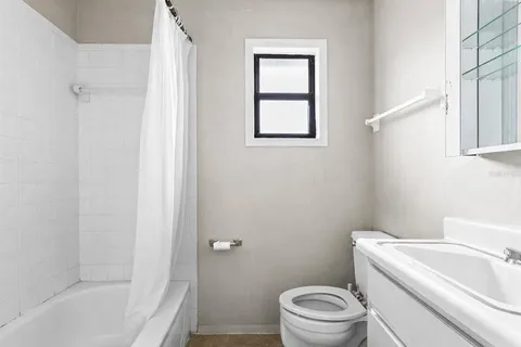 a white toilet sitting next to a bath tub