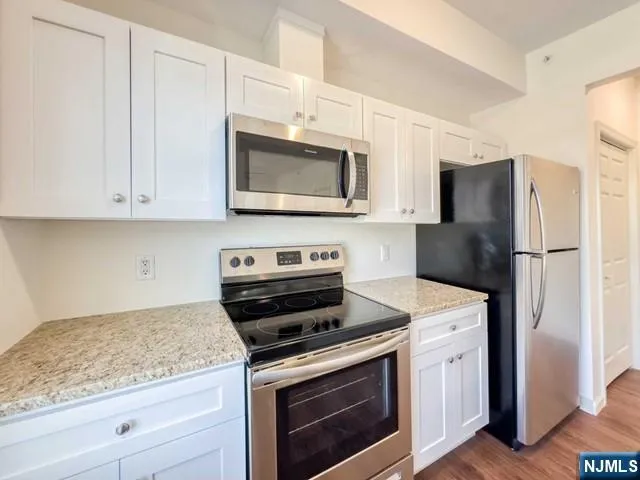 a kitchen with cabinets stainless steel appliances and a counter space