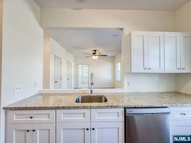 a kitchen with granite countertop a sink and cabinets