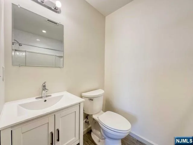 a bathroom with a toilet a sink and mirror