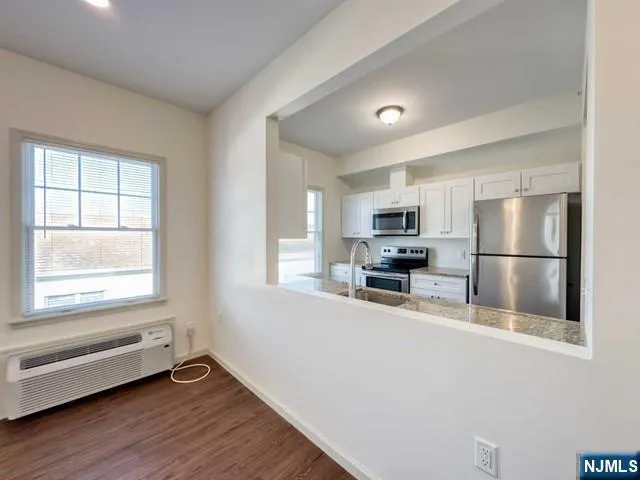 a kitchen with granite countertop a refrigerator and a stove top oven