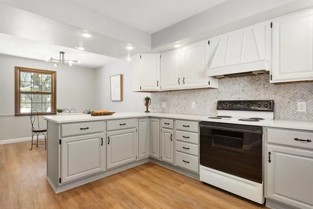 a kitchen with granite countertop white cabinets white stainless steel appliances and sink