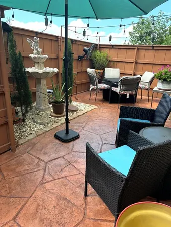 a view of a patio with table and chairs under an umbrella