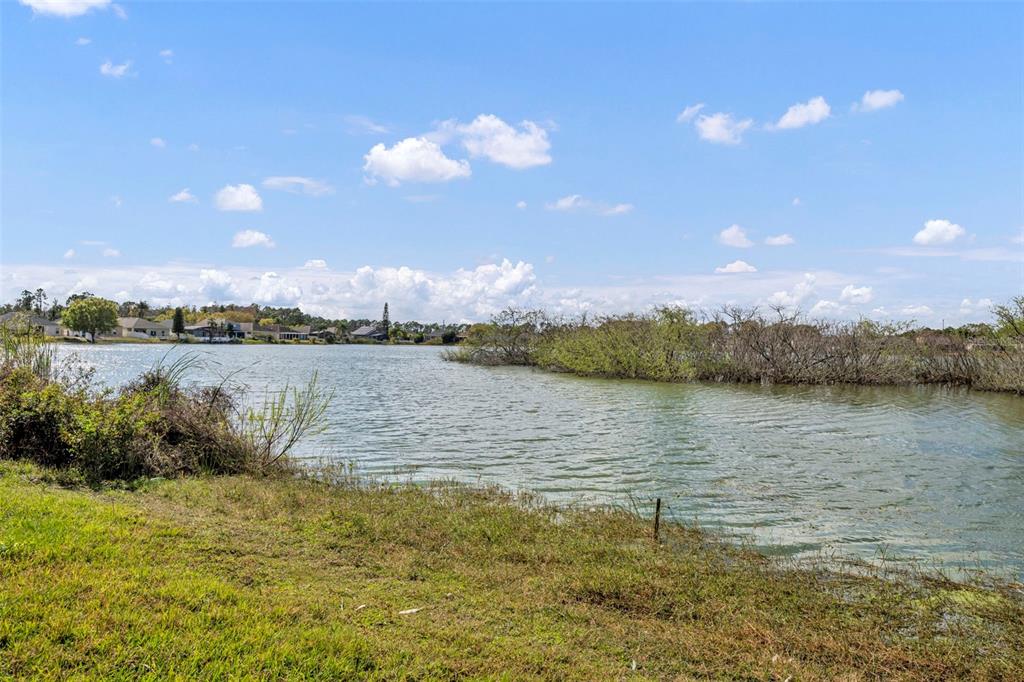 4718 Waterside Pointe Circle Orlando, FL 32829 - Photo 24 of 30 a view of a lake with houses in the background