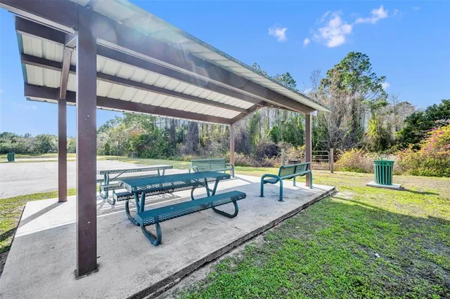 a swimming pool with chairs and table in the back yard