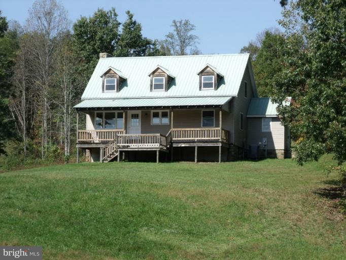 7037 Olinger Road Marshall, VA 20115 - Photo 29 of 30 a view of a white house with a big yard and large trees