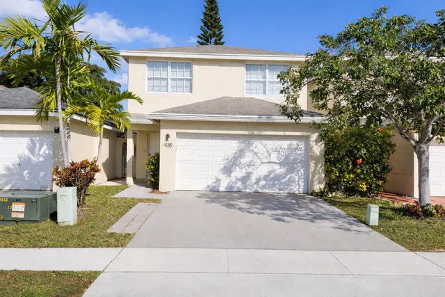 a front view of a house with a yard and a garage