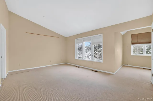 a view of an empty room with closet and wooden floor