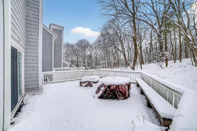 a view of a roof deck with couches and wooden fence