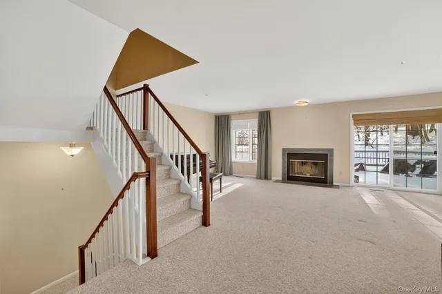 a view of an empty room with fireplace and a window