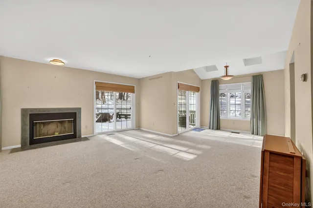 a view of an empty room with a fireplace and a window