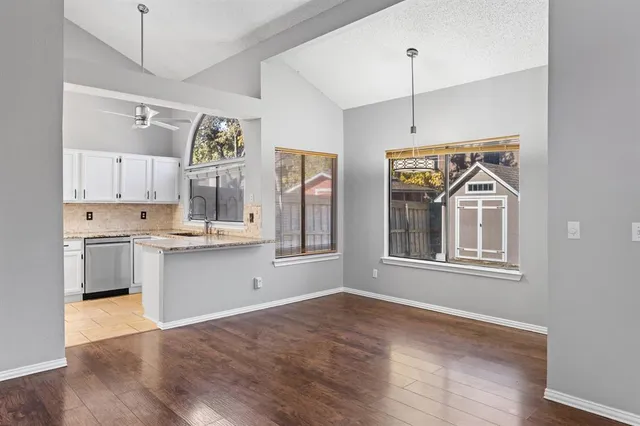 a kitchen with granite countertop white cabinets and window