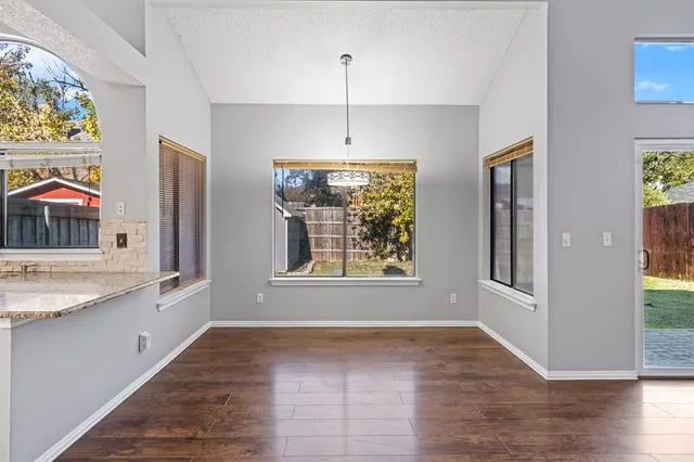 a kitchen with stainless steel appliances granite countertop a refrigerator a oven a sink with wooden floors and cabinets