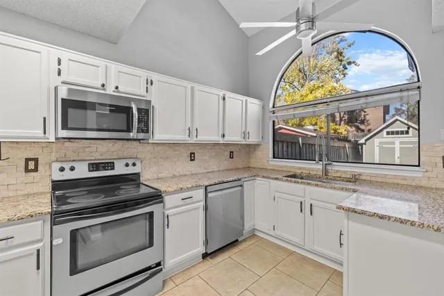 a kitchen with stainless steel appliances granite countertop a stove and a microwave
