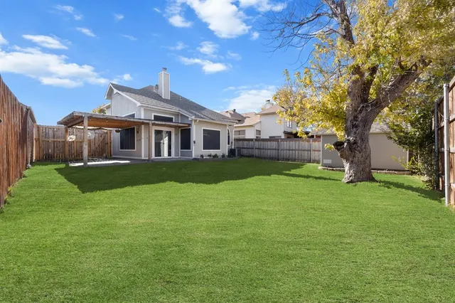 a view of a house with a big yard and a large tree