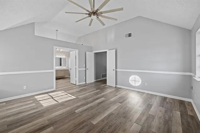 a view of a livingroom with wooden floor and a ceiling fan