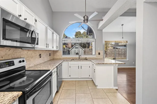 a kitchen with stainless steel appliances granite countertop a stove sink and microwave