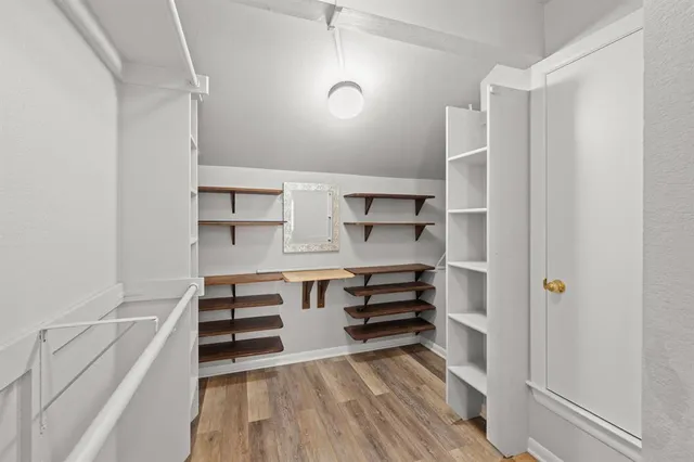 a view of walk in closet with empty racks