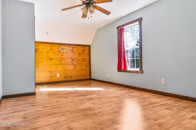 a view of a room with wooden floor and windows