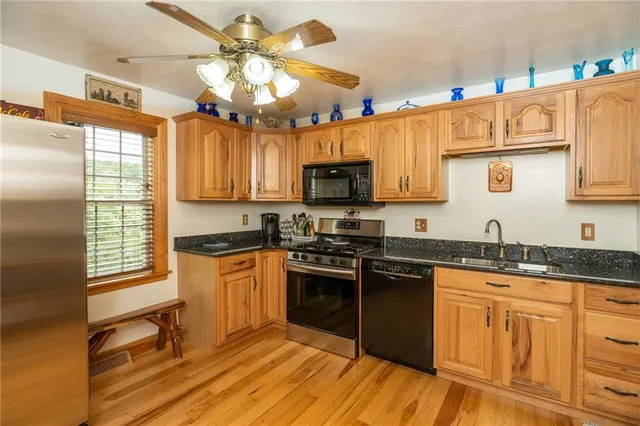 a kitchen with granite countertop a sink cabinets stainless steel appliances and a counter top space