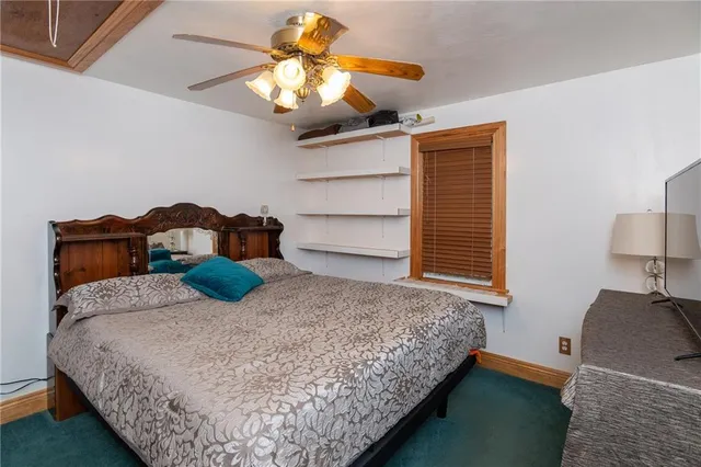 a bedroom with a bed and ceiling fan