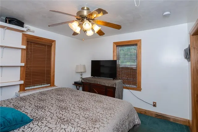 a bedroom with a bed and a flat tv screen on the dresser