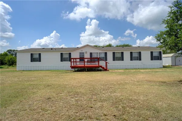 a view of a house with roof deck and a yard