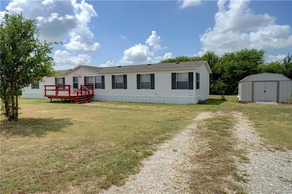 a view of a house with a yard and sitting area