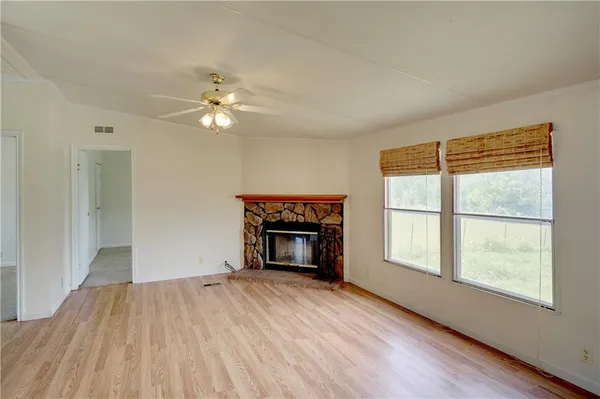 wooden floor fireplace and windows in an empty room