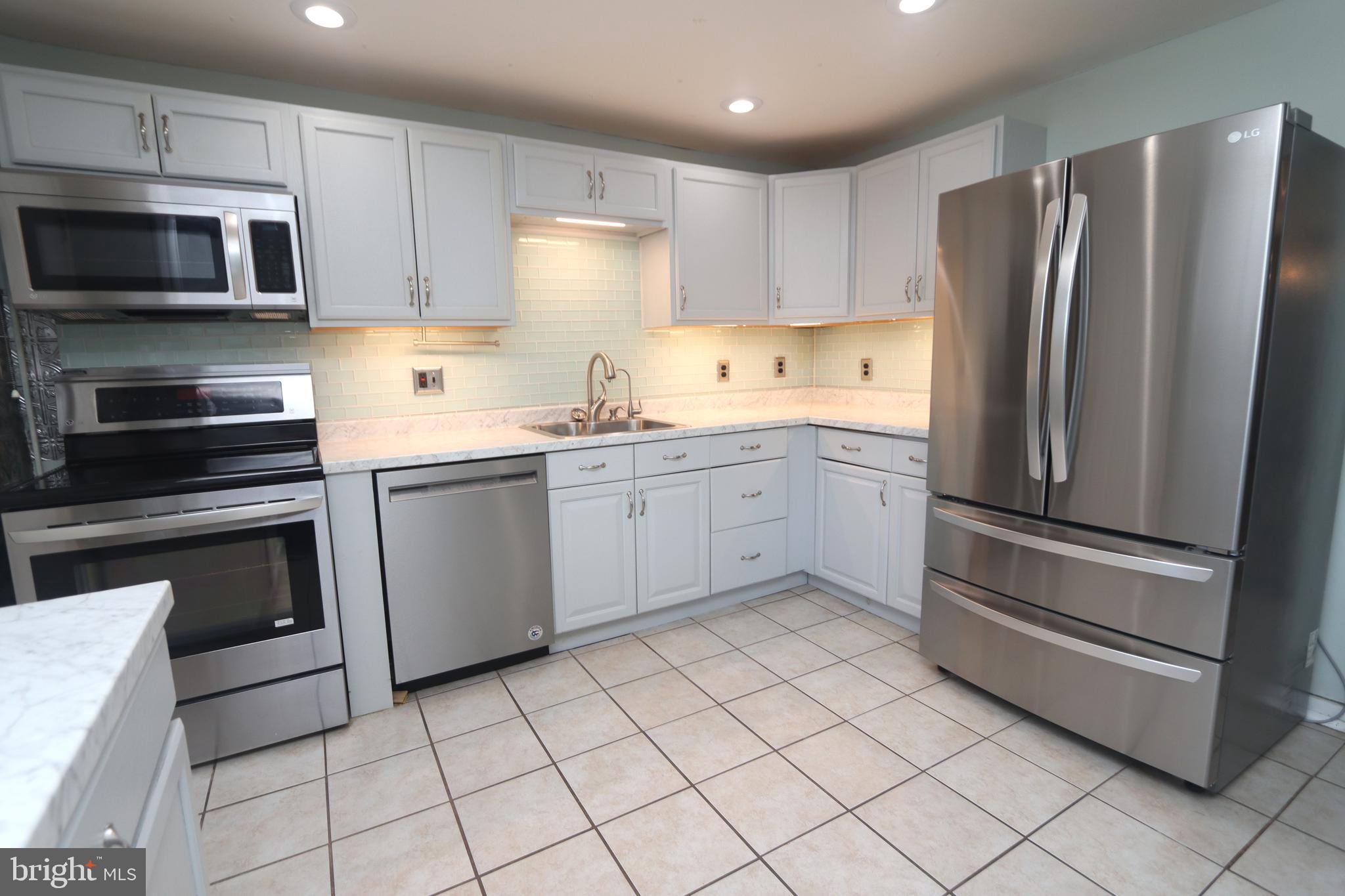 1012 Wells Street Conshohocken, PA 19428 - Photo 8 of 29 a kitchen with white cabinets stainless steel appliances and a sink