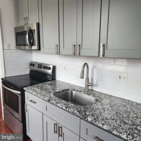 a kitchen with stainless steel appliances granite countertop a sink a stove and a microwave