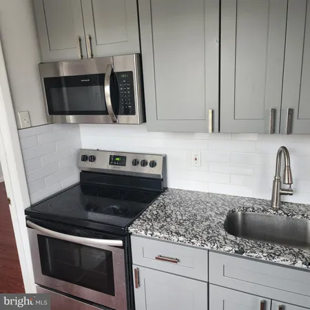 a kitchen with stainless steel appliances granite countertop a sink stove and microwave