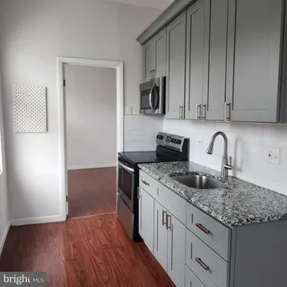 a kitchen with granite countertop a sink stove and cabinets