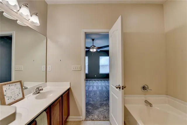 a bathroom with a tub sink and mirror