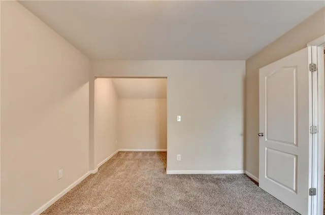 an empty room with closet area and mirrors